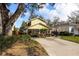 Charming yellow two-story home featuring mature landscaping and a basketball hoop at 3203 W San Carlos St, Tampa, FL 33629