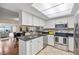 Well-lit kitchen featuring white cabinets, stainless steel appliances, and dark granite countertops at 3203 W San Carlos St, Tampa, FL 33629