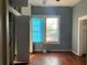 Shows a bedroom with wood floors, two windows, and blue walls at 3208 N 15Th St, Tampa, FL 33605