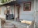 View of the home's front porch with a railing, steps, open door, and a chain link fence surround at 3208 N 15Th St, Tampa, FL 33605