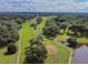 Panoramic aerial view of a beautifully landscaped golf course with ponds and mature trees at 37027 Lakota Ct, Zephyrhills, FL 33542