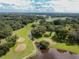 Breathtaking aerial shot of a golf course surrounded by trees and a pond at 37027 Lakota Ct, Zephyrhills, FL 33542