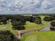 Aerial view of a sprawling golf course with water features, mature trees and walking paths at 37027 Lakota Ct, Zephyrhills, FL 33542