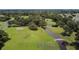 Scenic aerial shot of golf course with lush greenery, a bridge and mature trees on a bright day at 37027 Lakota Ct, Zephyrhills, FL 33542