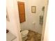 Compact powder room featuring a toilet, tile floors, and towel rack at 37027 Lakota Ct, Zephyrhills, FL 33542