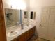 Well-lit bathroom featuring a double sink vanity with a large mirror and ample counter space at 37027 Lakota Ct, Zephyrhills, FL 33542