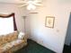 Cozy bedroom featuring a floral sofa, ceiling fan, and window with curtains at 37027 Lakota Ct, Zephyrhills, FL 33542