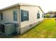 Exterior view of a home with neutral siding, dark shutters, and well-kept landscaping at 37027 Lakota Ct, Zephyrhills, FL 33542