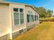 Home showcasing a view of manicured lawn, vinyl siding and black shuttered windows at 37027 Lakota Ct, Zephyrhills, FL 33542