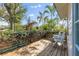 A wooden deck with two chairs, lush greenery, and palm trees offers a relaxing outdoor space at 468 11Th N Ave, St Petersburg, FL 33701