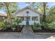 Inviting white bungalow with blue door, mature landscaping, and stone walkway at 468 11Th N Ave, St Petersburg, FL 33701