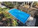 Backyard view of an above-ground pool covered with a blue tarp and surrounded by greenery at 468 11Th N Ave, St Petersburg, FL 33701