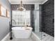 Bathroom featuring a soaking tub, walk-in shower, patterned floor, and modern lighting at 5292 Kernwood Ct, Palm Harbor, FL 34685