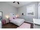 Cozy bedroom with a white bed, fluffy pink rug, and a ceiling fan at 5292 Kernwood Ct, Palm Harbor, FL 34685