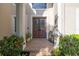 Elegant front entry featuring double doors with decorative glass, brick steps and potted plants, creating a welcoming entrance at 5292 Kernwood Ct, Palm Harbor, FL 34685