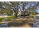 Beautifully landscaped front yard with mature trees, enhancing curb appeal at 5292 Kernwood Ct, Palm Harbor, FL 34685