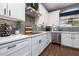 Well-equipped kitchen featuring sleek white cabinets, quartz countertops, stainless steel appliances, and stylish backsplash at 5292 Kernwood Ct, Palm Harbor, FL 34685