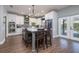 Modern kitchen with stainless steel appliances, white cabinetry, gray backsplash and an island with barstool seating at 5292 Kernwood Ct, Palm Harbor, FL 34685