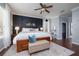 Main bedroom with a wood accent wall, white bedding, ceiling fan, and natural light at 5292 Kernwood Ct, Palm Harbor, FL 34685