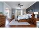 Main bedroom with a wood accent wall, white bedding, ceiling fan, and natural light at 5292 Kernwood Ct, Palm Harbor, FL 34685