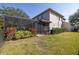 Exterior view of a screened-in pool area with lush landscaping providing privacy at 5292 Kernwood Ct, Palm Harbor, FL 34685