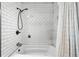 White subway tile bath with black fixtures and a patterned shower curtain at 5714 S 1St St, Tampa, FL 33611