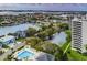 Aerial view showcasing waterfront homes, a pool area, and a high-rise building against the skyline at 5940 Pelican Bay S Plz # Ph E, Gulfport, FL 33707