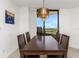 Formal dining area features a dark wood table with chandelier, perfect for entertaining with its sunny balcony view at 5940 Pelican Bay S Plz # Ph E, Gulfport, FL 33707