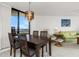 Cozy dining area open to living room, featuring a dark wood table, modern chandelier, and balcony access at 5940 Pelican Bay S Plz # Ph E, Gulfport, FL 33707