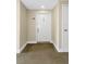 Hallway with neutral carpet leading to a white front door at 5940 Pelican Bay S Plz # Ph E, Gulfport, FL 33707