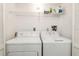 All white laundry room with washer, dryer and shelf storage at 5940 Pelican Bay S Plz # Ph E, Gulfport, FL 33707