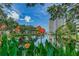 Picturesque view of the pond with orange canna flowers in the foreground and a modern condo building backdrop at 5940 Pelican Bay S Plz # Ph E, Gulfport, FL 33707