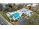 Aerial view of a clear blue swimming pool, surrounded by a sun deck, palm trees, and a clubhouse at 5940 Pelican Bay S Plz # Ph E, Gulfport, FL 33707