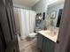 Bathroom featuring a shower-tub combo, a modern vanity, stylish shelves, and blue accents at 6113 Freeport Dr, Spring Hill, FL 34606