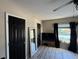 Bedroom featuring wood-look floors, black doors, a large window, and neutral walls at 6113 Freeport Dr, Spring Hill, FL 34606