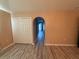 Upstairs hallway featuring neutral paint, wood floors, and an arched doorway at 6113 Freeport Dr, Spring Hill, FL 34606