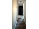 Hallway with luxury vinyl plank flooring, neutral paint, and black door at 6113 Freeport Dr, Spring Hill, FL 34606