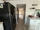 Hallway view featuring black stainless refrigerator and view of bright, airy living area at 6113 Freeport Dr, Spring Hill, FL 34606