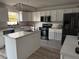 Bright kitchen featuring white cabinets, stainless steel appliances, and a center island at 6113 Freeport Dr, Spring Hill, FL 34606