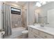 Well-lit bathroom featuring a shower-tub combo with grey tiling and a white vanity with a mirror at 706 Acacia Ct, Bradenton, FL 34212