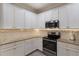 Bright kitchen featuring white cabinets, stainless steel appliances, and sleek countertops at 706 Acacia Ct, Bradenton, FL 34212