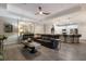 Spacious living room with black leather sofas, wood-look tile, and an open layout to the kitchen at 706 Acacia Ct, Bradenton, FL 34212