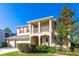 Two-story house with beige walls, red shutters, and a three-car garage at 7309 Night Heron Dr, Land O Lakes, FL 34637