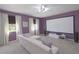 Home theater room painted in purple, features a projector screen and comfortable seating at 7309 Night Heron Dr, Land O Lakes, FL 34637