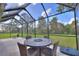 Relaxing screened patio with outdoor dining set and fire pit at 7309 Night Heron Dr, Land O Lakes, FL 34637