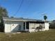 Exterior of home with a large backyard featuring green grass, a screened in porch, and a fenced in yard at 7998 115Th St, Seminole, FL 33772