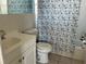 Clean bathroom with a patterned shower curtain and a vanity with storage at 7998 115Th St, Seminole, FL 33772