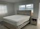 Bright bedroom featuring a neutral color palette, a window, and a wood-accented bed frame at 7998 115Th St, Seminole, FL 33772