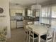 Bright eat-in kitchen with white cabinetry and a pendant light fixture over the dining table at 7998 115Th St, Seminole, FL 33772