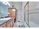 Bathroom featuring a vanity with a dark countertop, a tiled shower, and ample storage at 8510 Kentucky Derby Dr, Odessa, FL 33556